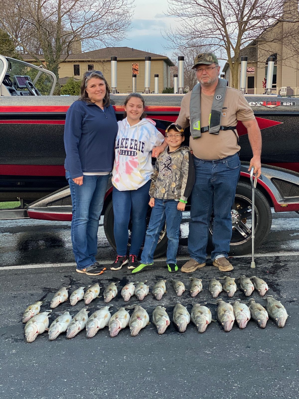A family enjoying a fishing day on Lake Erie with Huckeye Charters — kids, parents, walleye on ice