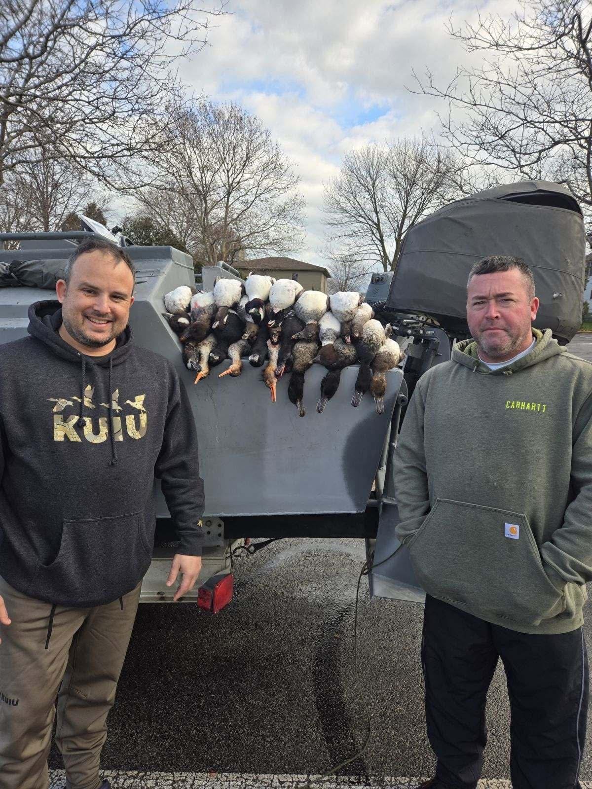 Two Huckeye Charters hunters with a Lake Erie mixed bag of ducks on the back of the boat after a standard waterfowl hunt