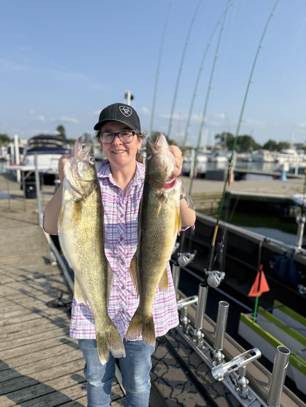 Angler on the Lorain dock holding two Lake Erie walleye — Huckeye Charters fishing report