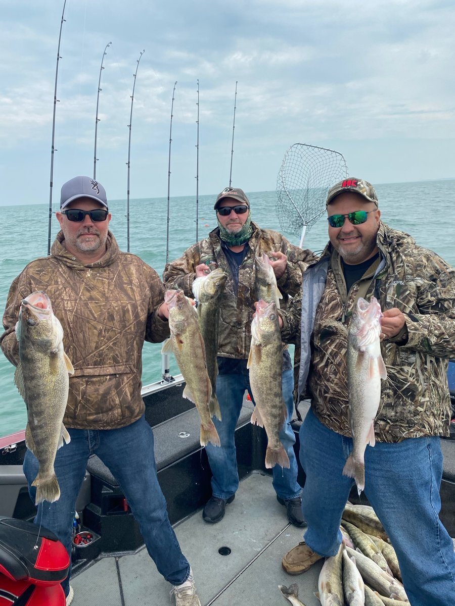 Three anglers holding a nice haul of Lake Erie walleye on a Huckeye Charters trolling charter